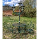 A cast iron four light garden lamp with table, five wrought iron chairs and two others, cast