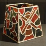 A leaded glass style four panel lamp shade, panels with stylised windmill, flowers, etc