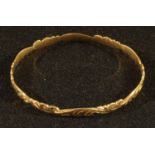 A 9ct gold bangle, engraved with scrolls and waves, 6.5cm diameter, 10.4g, boxed