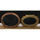 An Art and Crafts shaped rectangular brass looking glass, bevelled plate, 49cm x 71cm; another, oval