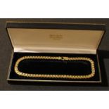 A 9ct yellow and white gold fancy link necklace, marked 375, 28.10g, boxed
