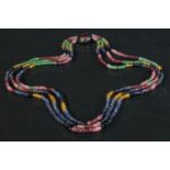 A three strand choker neclace, threaded with an arrangement of pink, blue, green and yellow