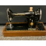 A vintage Singer electric sewing machine, no EH222540, oak case.