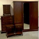 A Stag minstrel bedroom suite, comprising a triple wardrobe, central bevel edge mirrored door, 204cm