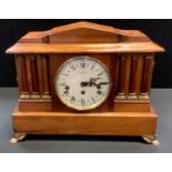 An early 20th century wooden mantel clock, architectural pediment, the face with Roman numerals