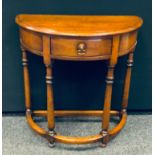 A 20th century oak demi-lune hall table, central single frieze drawer, brass handle, 71cm high, 71cm