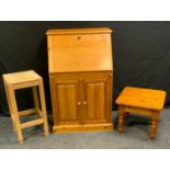 A contemporary pine bureau, fall front enclosing pigeon holes above a pair of cupboard doors,