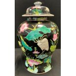 A Chinese famille vert urnular temple jar and cover, printed with birds, lily pads, etc, black