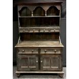 A modern stained pine dresser, stepped cornice, arched alcoves, shelving and spice drawers to top,