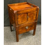 A George III mahogany tray top commode, pierced handles above a pair of cupboard doors and a