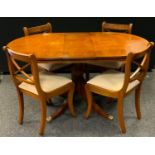 A late 20th century burr walnut veneered breakfast table, oval top, turned column, sabre legs, paw