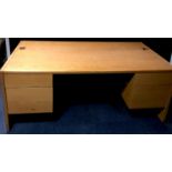 A large light oak veneered office desk, rectangular top, kneehole flanked by drawers. 73cm high x