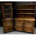 A Jaycee Furniture oak priory style dresser, shaped uprights and shelves to top, two null fronted