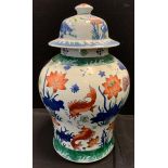 A Chinese urnular temple jar and cover, painted with a fish bowl scene, 43cm high