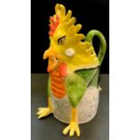 A Prue Piper (b.1938) novelty jug in the form of a ferocious cockerel a winged dragons body the tail