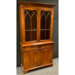 A late 20th century burr walnut library bookcase, moulded cornice above a pair of astragal doors