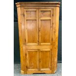 A Victorian pine floor standing corner cupboard, two long over two short panelled doors, 190cm high,
