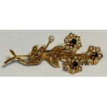 A mid 20th century seed pearl and deep blue sapphire floral spray brooch, sinuous triple flower head