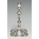A George III cast silver taperstick, knopped stem, shaped square base with shells to angles, 13.