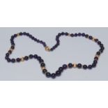 A graduating amethyst and gold bead necklace, tapering amethyst beads section-ally divided by twenty