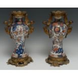 A pair of ormolu mounted 17th century Japanese baluster vases, painted in the Imari palette with