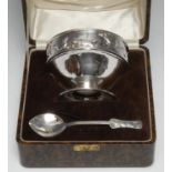 An Arts and Crafts silver child's bowl and spoon, chased with foxes and geese, spreading circular