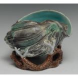 A majolica spoon warmer, as a shell, glazed in tones of turquoise, green, brown and grey, 15.5cm