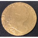 An 18th Century George III 1774 gold spade guinea coin having a laureate bust of King George and