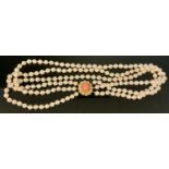 A coral and cultured pearl collar necklace, three strands of creamy white uniform cultured pearls,