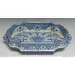 A French Baroque design faience armorial shaped rectangular dish, decorated in underglaze blue