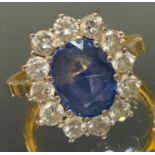 A sapphire & diamond cluster ring, the central oval pale blue sapphire measuring approx 9.67mm x 7.