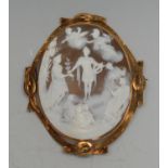 A gold coloured metal mounted shell cameo brooch, carved with The Apotheosis of Apollo, the mount