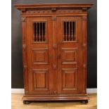 An oak bread and cheese or food cupboard, outswept cornice above a pair of spindle and geometric
