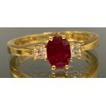 A ruby and diamond trilogy ring, central oval red ruby approx 0.50ct, flanked by a princess cut