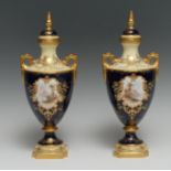 A pair of Coalport two handled pedestal ovoid vases and covers, decorated with landscapes in