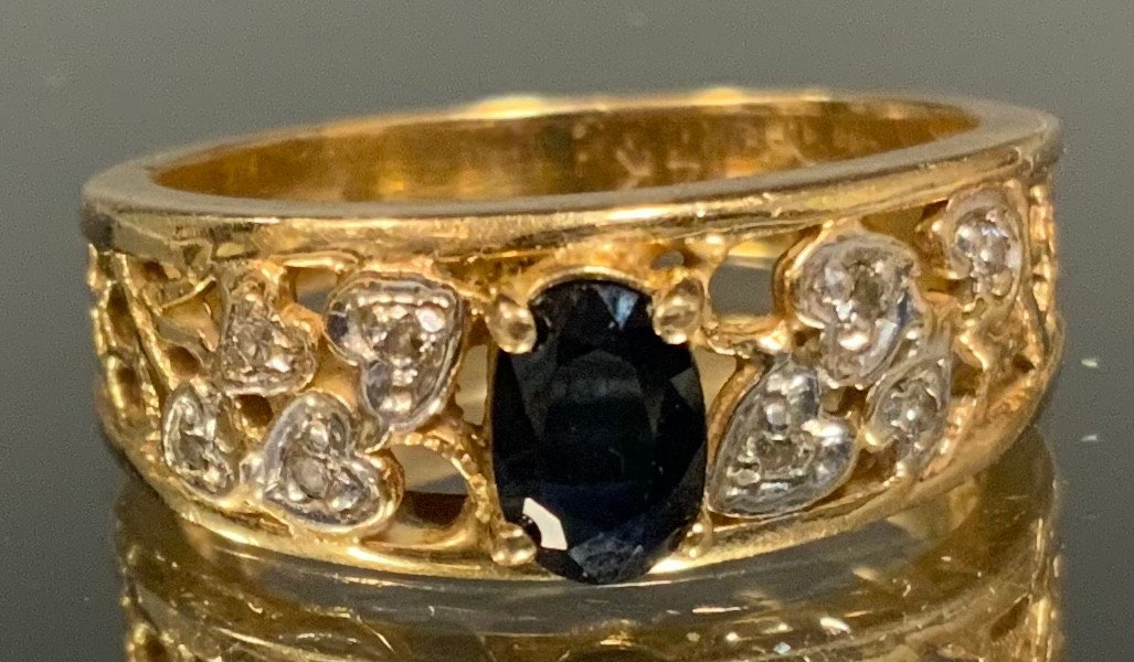 A sapphire and diamond ring, raised quarter claw set deep blue oval sapphire approx 0.45ct above