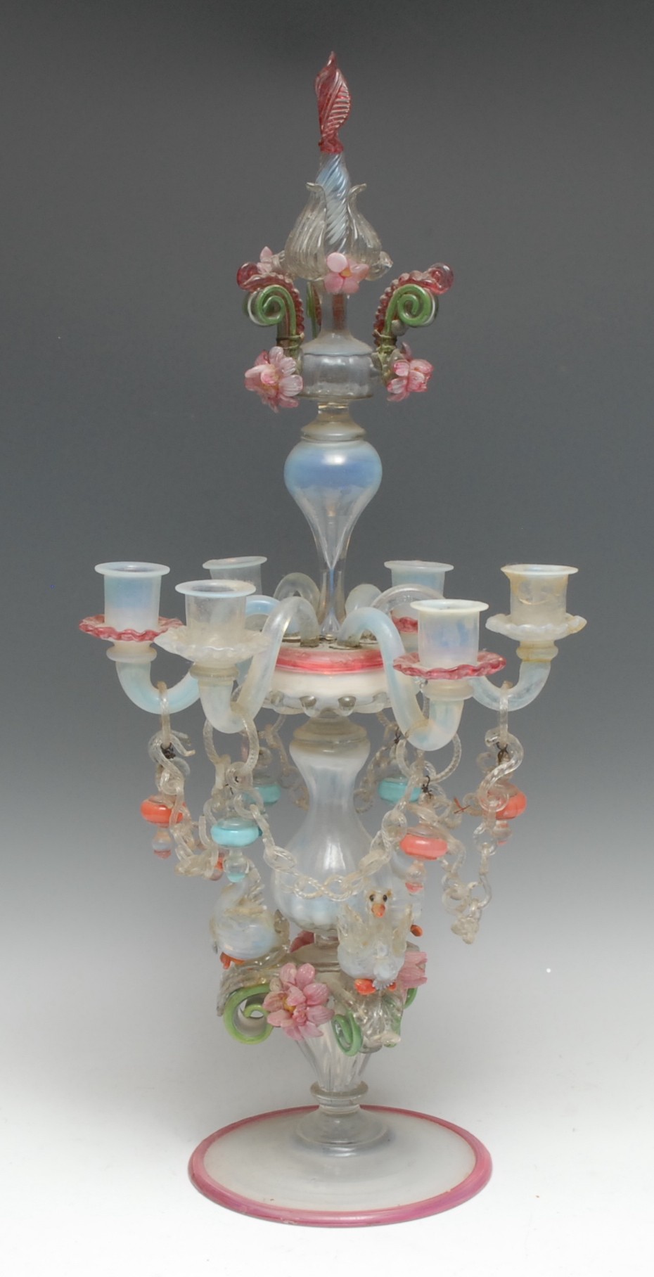 An Italian glass six-light candelabrum, decorated throughout in tones of pink, blue, green and