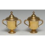 A composed pair of George V silver-gilt miniature two-handled cups and covers, of 18th century