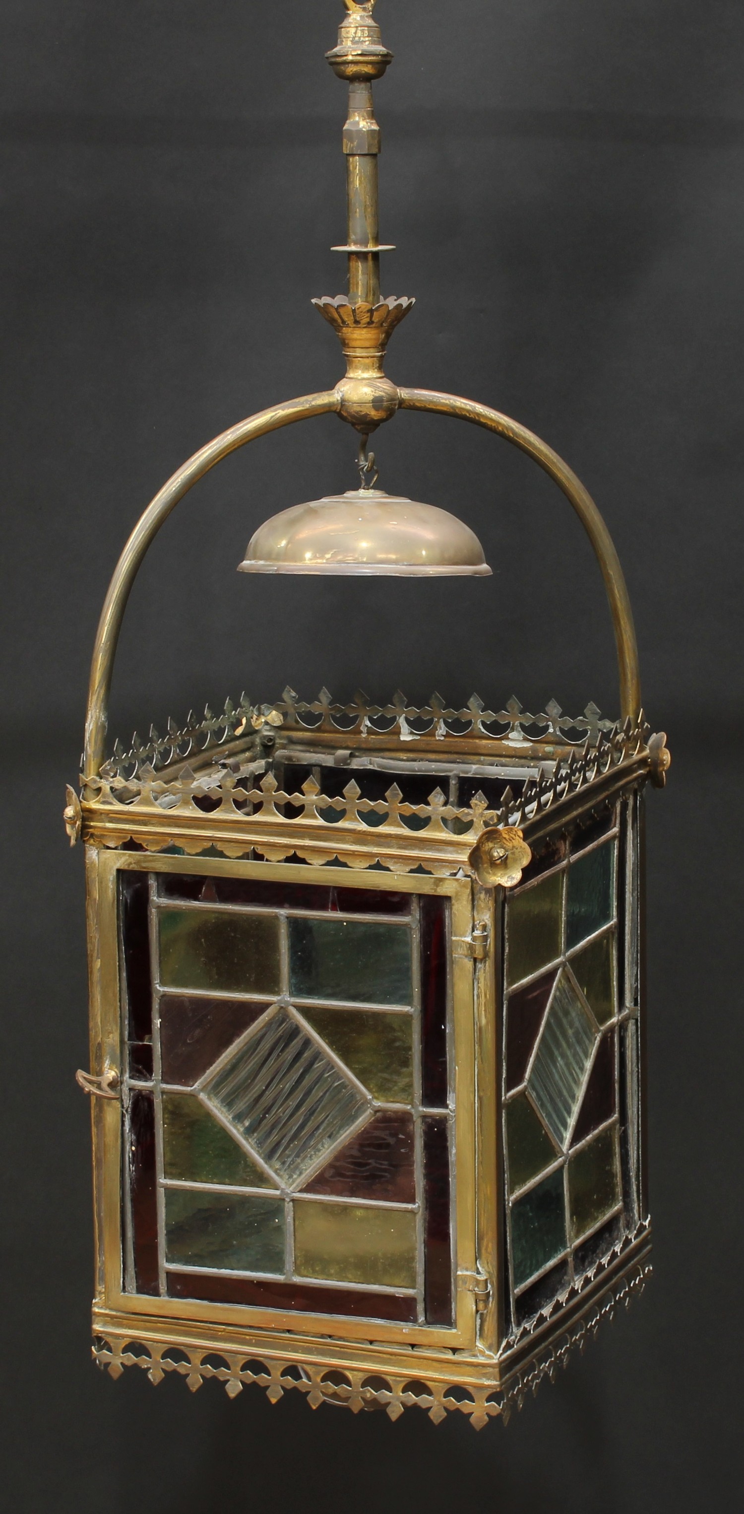 A Reformed Gothic lacquered brass and stained glass ceiling lantern, the leaded glass panels crested