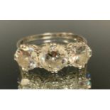 A diamond trilogy ring, linear set with three large graduated old round cut diamonds, central