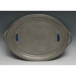 An Art and Craft hammered oval two handled pewter tray, applied with two Ruskin type oval panels,