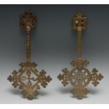 An Ethiopian Coptic brass cross, 36cm long, 19th/early 20th century; another, similar (2)