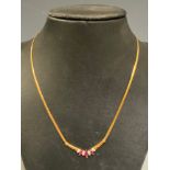 An 18ct gold ruby and diamond necklace, central cluster of three navette pinky red rubies and