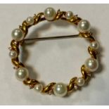 A modern diamond and cultured pearl brooch, inset with twelve creamy white globular pearls and