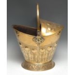 A 19th century brass helmet shaped coal scuttle, chased with bands of stiff acanthus, swing