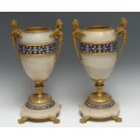 A pair of 19th century French champleve enamel, gilt bronze and onyx ovoid urns, the handles cast as