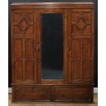 An oak wardrobe, of 17th century inspiration, flush cornice above a central mirrored door