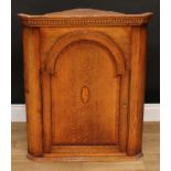 A George III style oak splay-fronted wall hanging corner cupboard, 82cm high, 69cm wide, 35.5cm deep