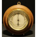 A late 19th/early 20th century circular aneroid barometer, the dial with crescent shaped