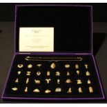A Tutankhamun Charm Necklace, comprising sterling silver chain and thirty one gold plated charms,